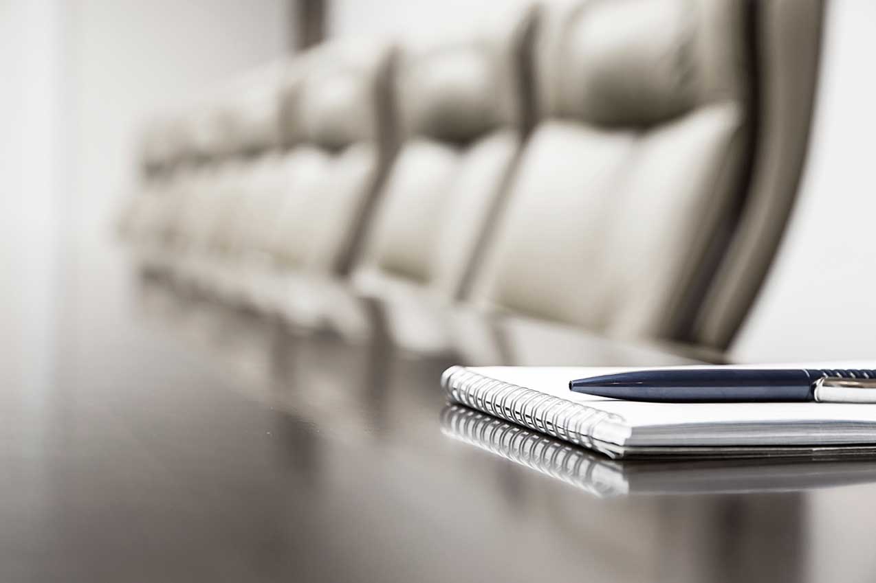 A table with a phone and some chairs in the background