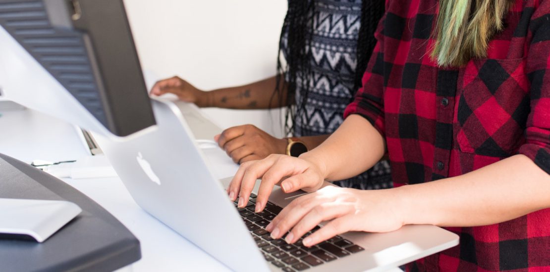 A group of people using laptops on a table.