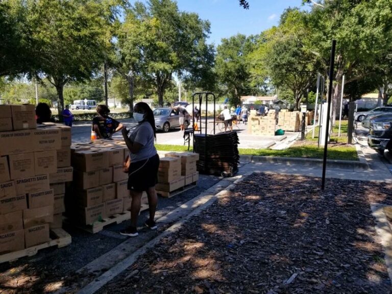 A group of people standing around boxes on the ground.