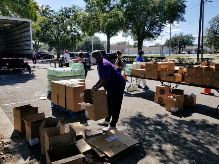 A woman standing next to boxes on the ground.